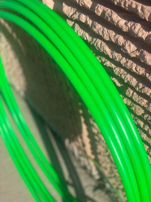 Green tubing against a stone wall.