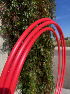 Red tubing near green foliage - 389C964D