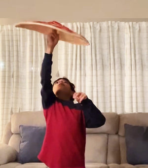 Boy tossing pizza dough