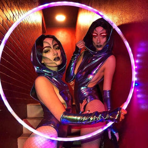 Two futuristic performers with a glowing hoop.