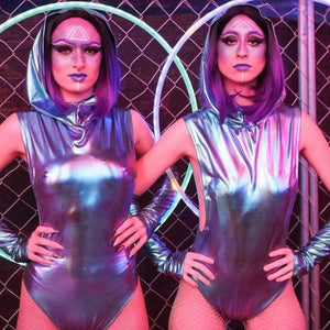 Two futuristic performers in silver outfits