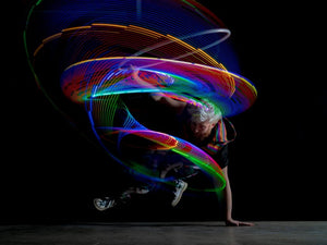 Evan breakdancing with colorful light trails