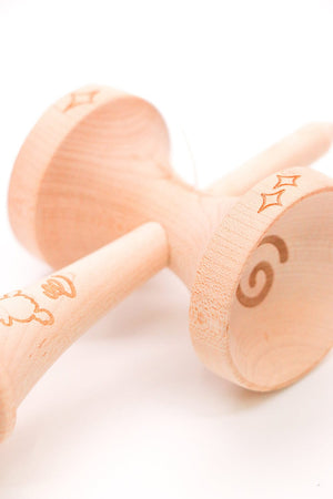 Wooden kendama toy with etched designs.