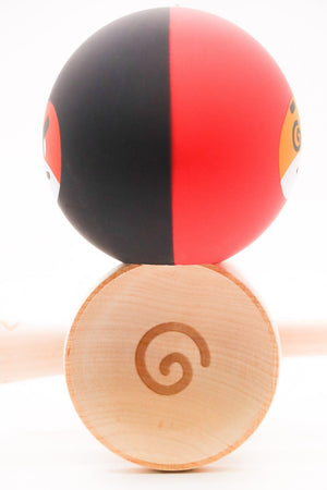 Half black and red ball on a wooden base.