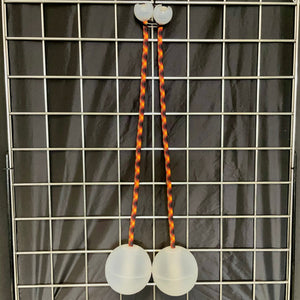 Two white balls connected by orange and brown cords.