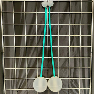 Two white balls connected by teal strings, hanging on a grid.