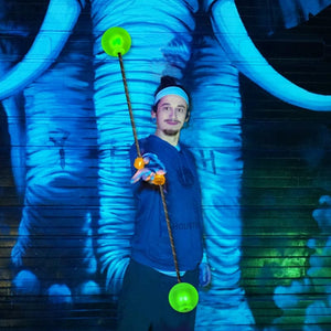 Man performing poi action with glowing orbs.