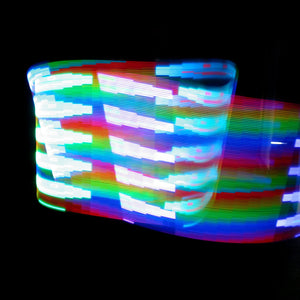 Rainbow light trails against black background