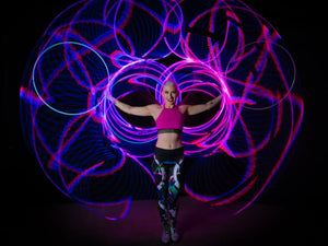 Woman with light hoops, creating a vibrant light show.