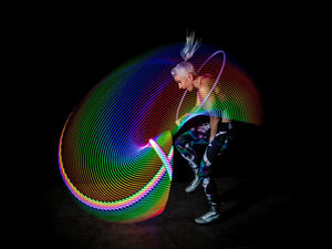 Woman with colorful light trails performing.