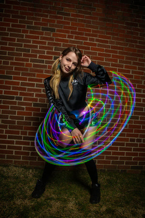 Mina V2b with a colorful illuminated hoop in front of brick wall