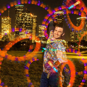 Man spinning Helix Poi Pro lights with city skyline.