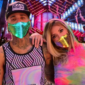 Guy and girl wearing glowing LED masks at a festival.